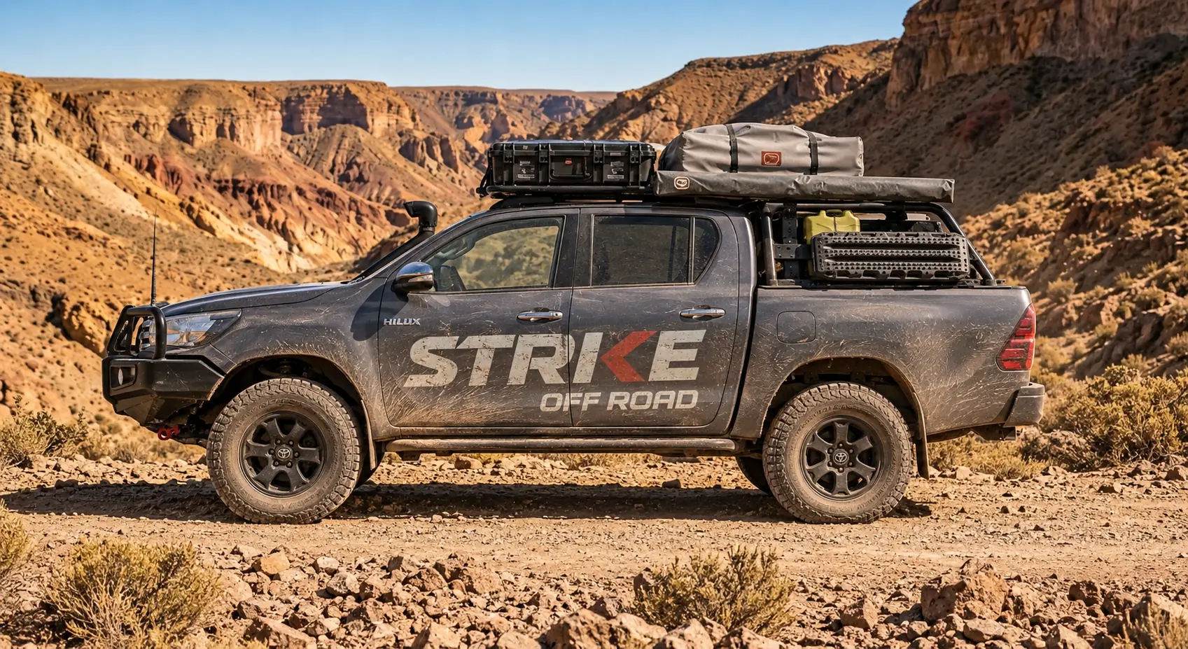 Toyota Hilux gris equipada por Strike Off Road, de costado, en un cañón